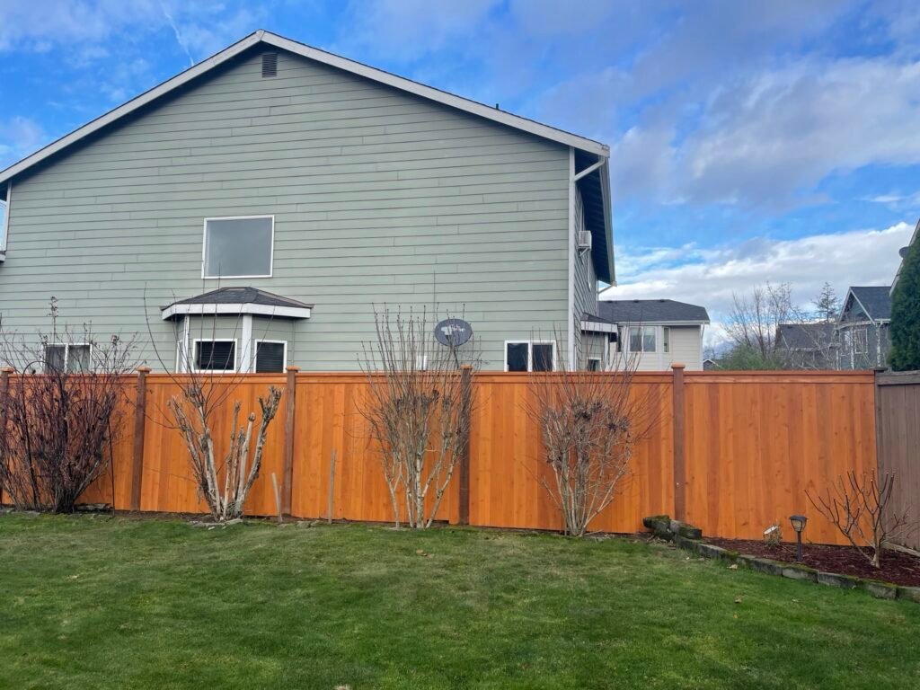 Completed cedar privacy fence across a landscaped backyard